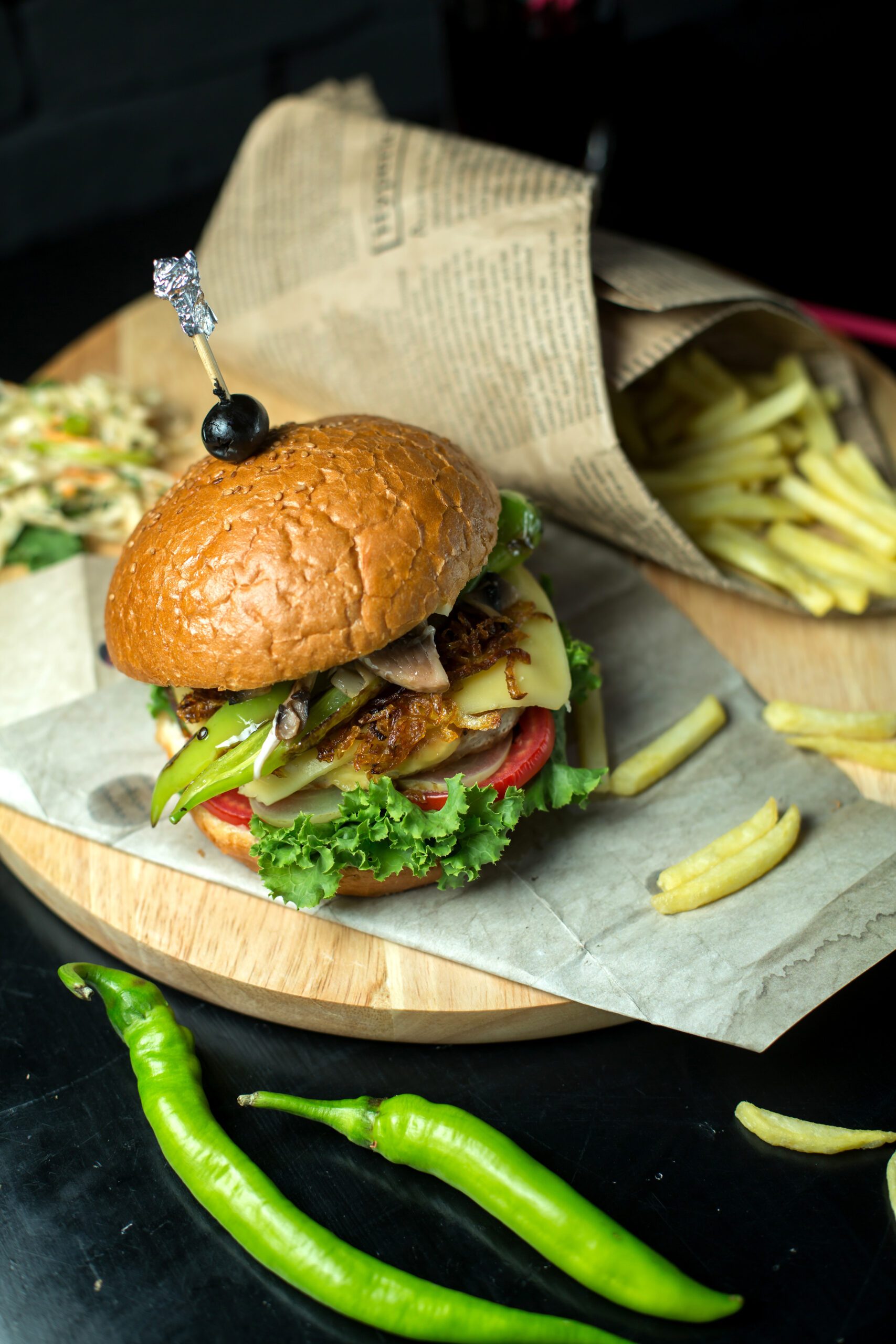 top view burger with french fries and green pepper on a blackboard